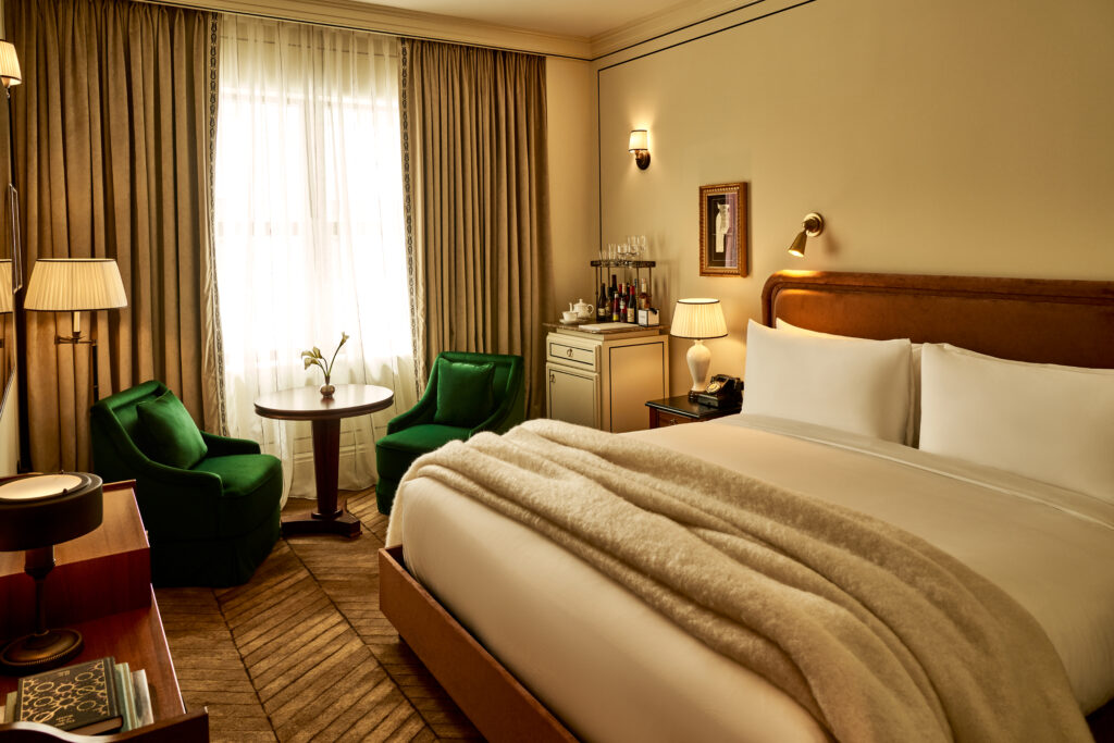 Angled view of the Superior Room at The Twenty Two New York, featuring a king-size bed with a minibar in the background, blending luxury and comfort.