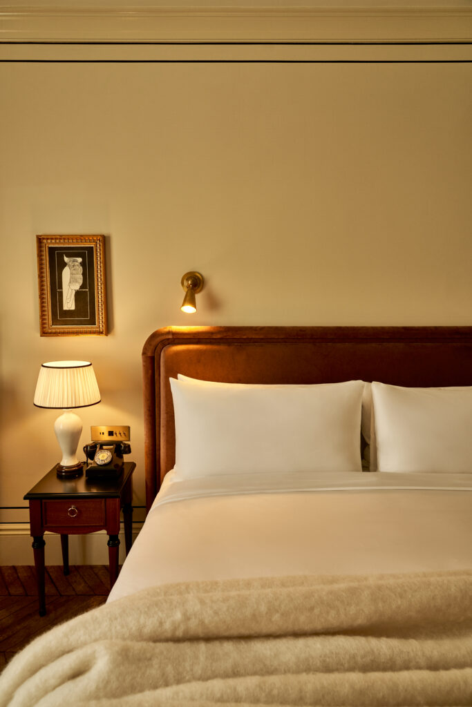 Close-up of the king-size bed and side table with a vintage rotary phone in the Superior Room at The Twenty Two New York, showcasing timeless elegance.