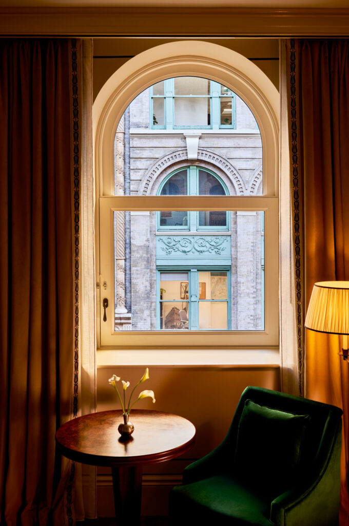 Close-up of an elegant chair by the window in the Superior Room at The Twenty Two New York, offering a cozy spot with a view.